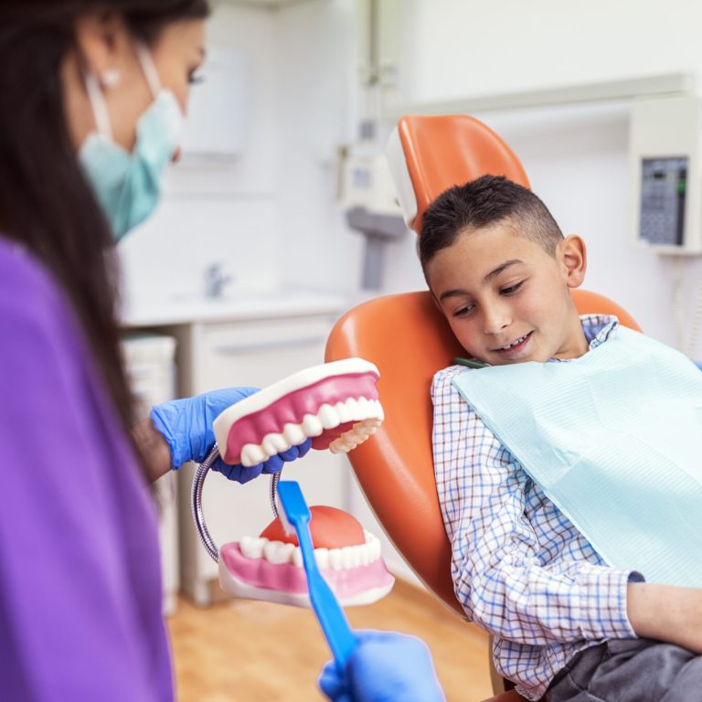 Doctor dentist teaching a child to brush teeth. Dentist concept.
